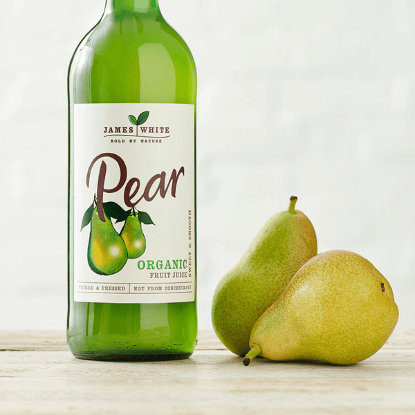 Organic pear juice in a clear glass bottle of 250ml with fresh pears nearby on a natural wooden background
