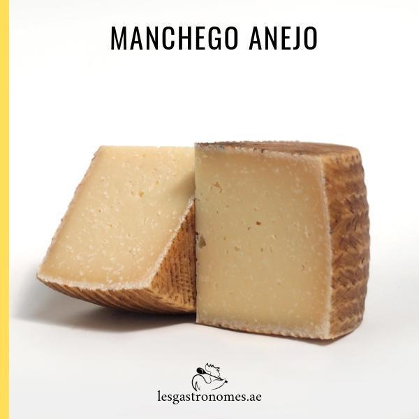 Aged manchego cheese DOP with 12 months maturation, showing a cut wedge with visible texture on wooden board