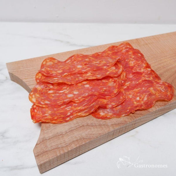 Spicy beef salami spianata sliced on wooden cutting board, ready-to-eat premium Italian meat perfect for antipasti - 250g