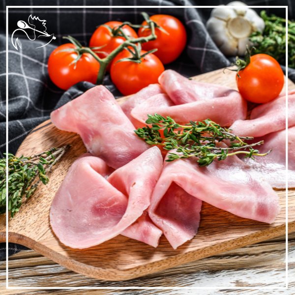 Sliced halal veal cooked ham with a delicate pink color, presented on a white plate, perfect for sandwiches and meals.