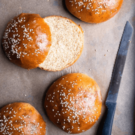 Freshly baked artisan brioche burger buns in a pack of 4, golden-brown with soft texture, ideal for gourmet burgers