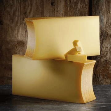 Beaufort tradition AOP cheese wheel from French Alps, aged with raw milk, showing pale yellow texture and natural rind