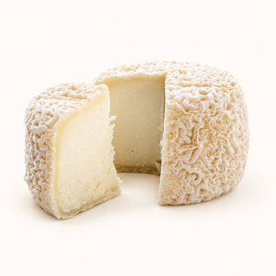 Crottin de Chavignol Chèvre 60 g sliced to show its ivory goat-cheese interior