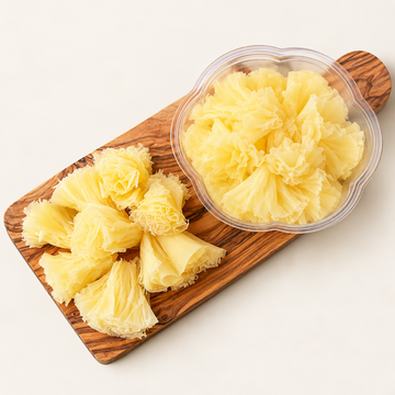 Tête de Moine cheese rosettes with clear unbranded container, illustrative studio image