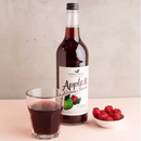 Organic apple and summer berries juice in a glass bottle of 250ml with fresh ingredients displayed around it