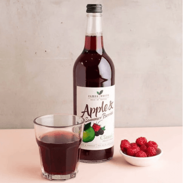 Organic apple and summer berries juice in a glass bottle of 250ml with fresh ingredients displayed around it