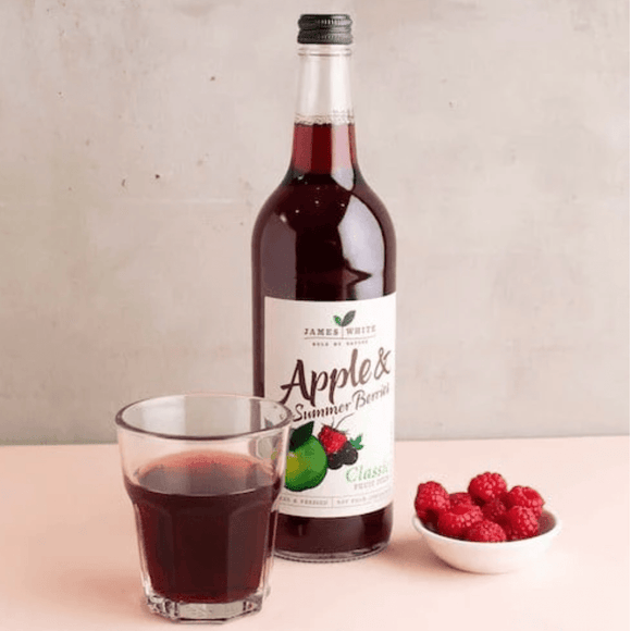 Organic apple and summer berries juice in a glass bottle of 250ml with fresh ingredients displayed around it