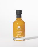 A bottle of À L'Olivier Vinegar & Mango, featuring a luxurious amber-colored fruit vinegar infusion in elegant packaging