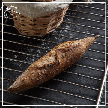 Freshly baked artisan French mini multi-grain baguettes, crusty golden brown exterior with visible seeds and grains