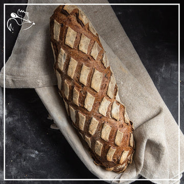 Freshly baked artisan multigrain bread loaf with crispy crust and wholesome grains, perfect for sandwiches or toast