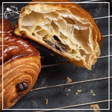 Artisan pain au chocolat pastries with premium Valrhona chocolate filling, freshly baked pair ready to enjoy