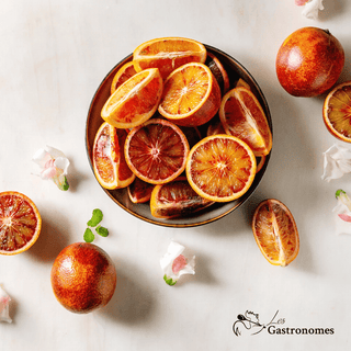 Blood oranges sanguinelli 1kg in a mesh bag, showing vibrant red-orange exterior and juicy ruby-colored flesh, ready to eat