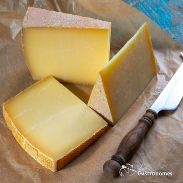 Delicious Comte AOP cheese aged 12 months with a golden-yellow rind and a smooth texture, perfect for a gourmet platter.