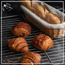 Continental breakfast with fresh croissants, coffee, juice, and fruits served on a wooden table for a delightful morning meal